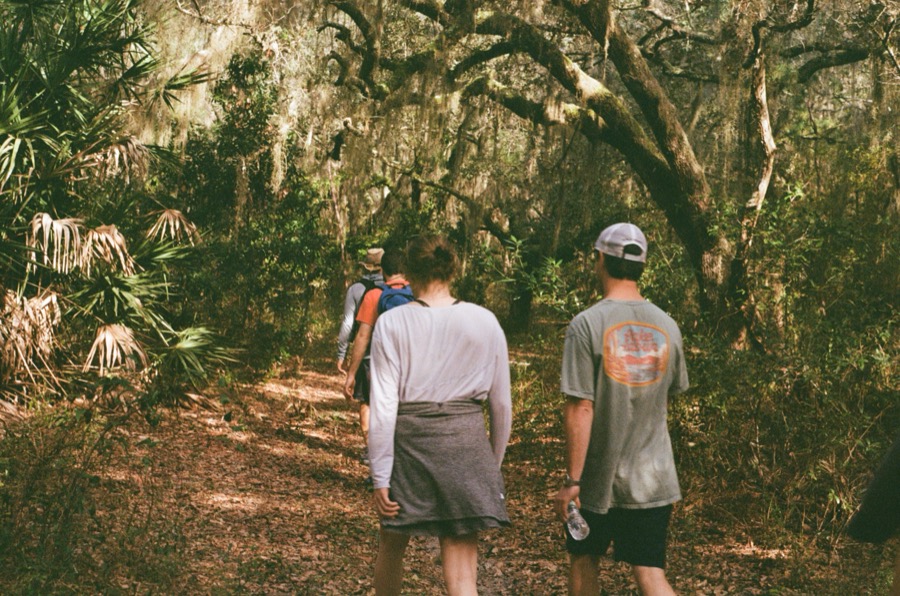 The family walking single file on the trail near Lake Whitney